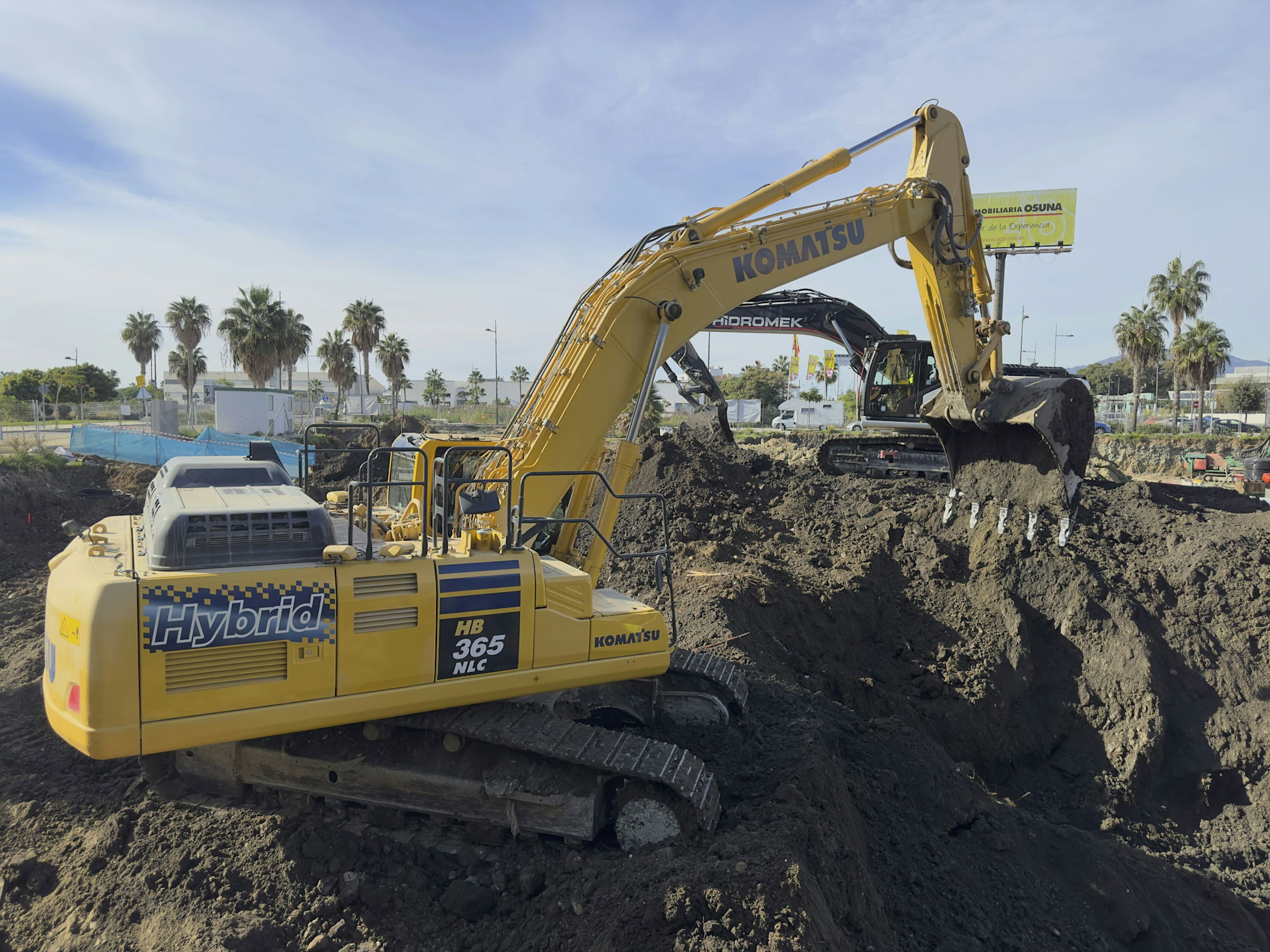 a-large-yellow-excavator-sitting-on-top-of-a-pile-of-dirt.jpg A large yellow excavator sitting on top of a pile of dirt